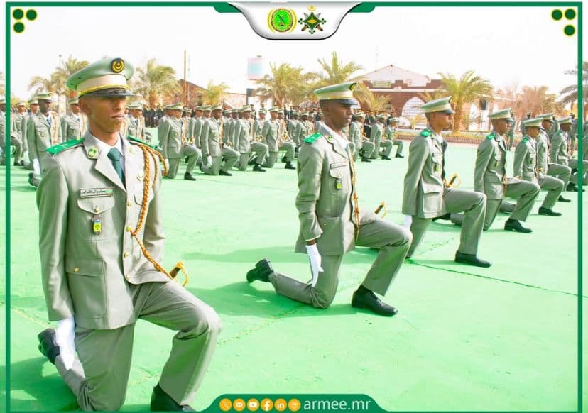 Élèves-officiers recevant leurs galons, un genou à terre